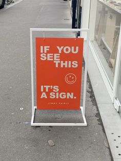 an orange sign that says if you see this it's a sign on the sidewalk