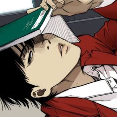 a man laying on the ground with his head under an open book while he is brushing his hair