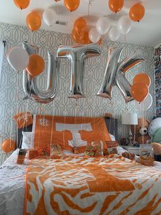 an orange and white bedroom with balloons in the shape of the letter u on the wall