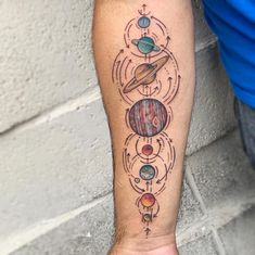 a person with a tattoo on their arm that has different planets and stars in it