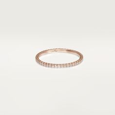 a rose gold wedding band with small diamonds on the inside and outside, set against a white background