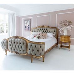 a large bed sitting next to a window in a room with pink walls and white flooring