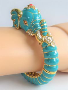 "Limited Edition Kenneth J Lane Turquoise Raj Elephant Bangle bracelet. This stunning bracelet showcases a turquoise enameled elephant with 18kt. gold accents and bright and shiny Swarovski inlaid crystals. Atop his head is an orange round cabochon surrounded by crystals as well. Measures 2 1/4\" L X 1 3/4\" W. It is secured by a spring hinged closure and Hallmarked KJL. It is unworn and will come in it's original red Kenneth J Lane felt pouch for immediate gift giving or to be enjoyed by you. W Elephant Bangle, Figural Jewelry, Felt Pouch, Animal Bracelet, Elephant Jewelry, Big Jewelry, Elephant Bracelet, Unique Accessories, Colorful Bags