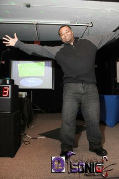 a man standing in front of two televisions with his arms spread out and hands outstretched