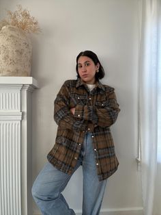 a woman standing in front of a white wall with her hands on her hips and looking at the camera