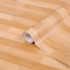 a wooden floor with a roll of clear vinyl on it