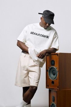 a man standing next to a wooden speaker