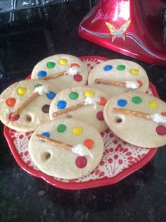 cookies decorated with icing and candy on a red plate