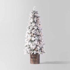 a small white christmas tree in a pot