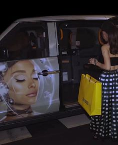 a woman is standing in front of a van with a large advertisement on it's side