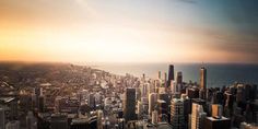 an aerial view of a large city with tall buildings and the ocean in the background