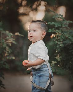 a young boy holding an apple in his hand