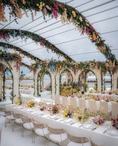 an image of a table set up with flowers and greenery on the ceiling for a wedding