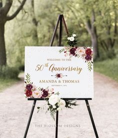 a sign with flowers and greenery on it that reads welcome to the anniversary amanda & thomas