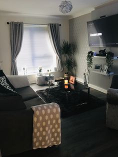 a living room filled with furniture and a flat screen tv mounted to the side of a wall