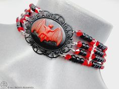 Victorian Vampire Bat Choker Gorgeous completely handmade vampire bat cameo choker in Victorian style. - Lots of black glossy beads and bloody red facetted beads separated by Rhinestone ornaments. - Bloody red resin Bat Cameo. - Beautifull silver color vampire ankh. (5.5cm in length) - Completely handmade. Available in 2 lenghts: Maximum length 36cm or 33cm. Make your choice in the drop down menu box. Worldwide Shipping More jewellery, accessories, altar equipment and much more can be found at w Handmade Halloween Choker As Gift, Handmade Halloween Choker Gift, Handmade Halloween Choker For Gift, Red Punk Choker As Gift, Gothic Halloween Costume Choker, Halloween Gothic Costume Choker, Halloween Cosplay Choker Necklaces, Halloween Cosplay Choker Necklace, Punk Costume Choker Jewelry