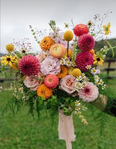 a bouquet of flowers is sitting in the grass