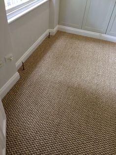 an empty room with carpeted floors and white walls