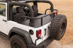 a white jeep parked on top of a grass covered field