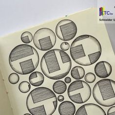 an open book with black and white drawings on the pages that have circles in them