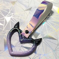 a pair of scissors sitting on top of a purple object with glitters around it