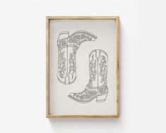 the letter u is made up of cowboy boots and floral designs, framed in a wooden frame