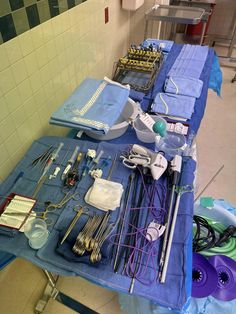 medical supplies are laid out on a table in a room with tiled walls and flooring