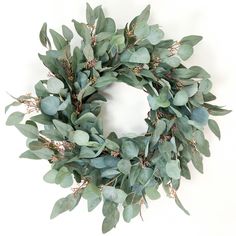 a wreath with green leaves and branches on a white background, ready to be used as an ornament