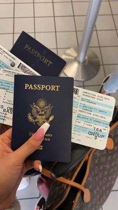 a person holding a passport in their hand and boarding tickets on the other side of them