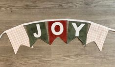 a banner with the word joy hanging from it's side on a wooden floor