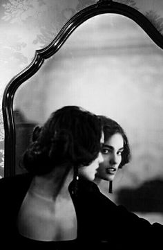 a woman looking at herself in the mirror