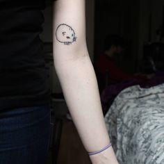 a woman's arm with a small tattoo of a hedge on the left side of her arm