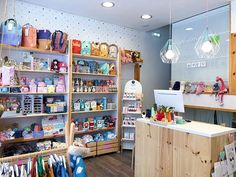 the inside of a children's clothing store with lots of shelves and toys on display