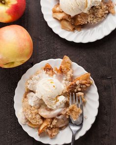 two white plates topped with dessert next to an apple