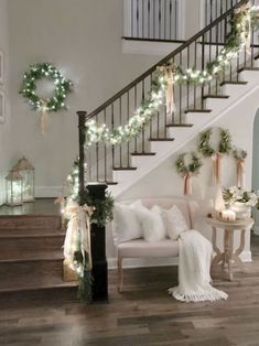 the stairs are decorated with garlands and lights for holiday decorating in this living room