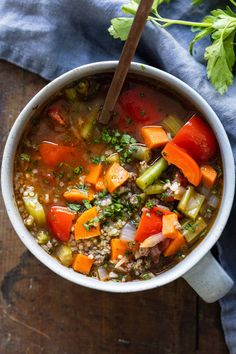 a bowl of soup with carrots, celery and other vegetables in it