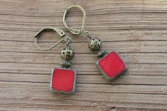 Red Earrings Dangle / Drop Earrings / Czech Glass Earrings / Gift for women / Gift for her Color : Opaque Red Picasso 10mm Square Czech Glass Beads. Finish : Antique brass tone findings. Size : Approx 1,5 inches including the antique Brass tone lever back. Ear wires : Antique brass tone lever back. Czech Glass Earrings : https://www.etsy.com/shop/NtikArtJewelry?ref=hdr_shop_menu&section_id=16062218 To visit my shop " NtikArtJewelry ": https://www.etsy.com/shop/NtikArtJewelry FREE DOMESTIC SHIPPI Red Bohemian Rectangular Earrings, Bohemian Red Rectangular Earrings, Red Brass Earrings With Ear Wire, Red Metal Dangle Earrings, Red Metal Drop Earrings, Red Brass Drop Earrings, Red Dangle Earrings With Lever Back Ear Wires, Nickel-free Red Drop Earrings, Red Brass Dangle Jewelry