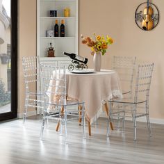 a dining room table with chairs and a vase filled with flowers