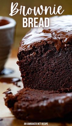 a close up of a piece of cake on a table with a cup of coffee in the background