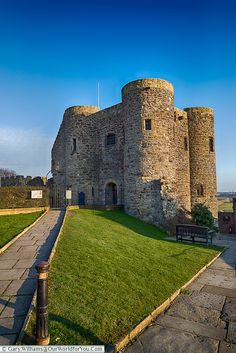 an old stone castle sitting on top of a lush green field