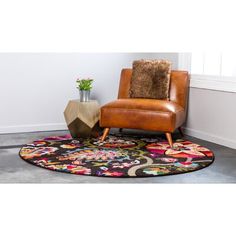 a brown chair sitting on top of a rug next to a vase filled with flowers