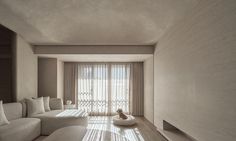 a living room with white furniture and curtains