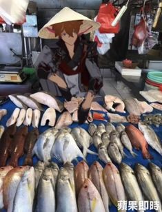 a woman kneeling down next to some fish