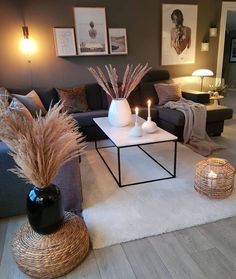 a living room with couches, tables and candles on the coffee table in front of them