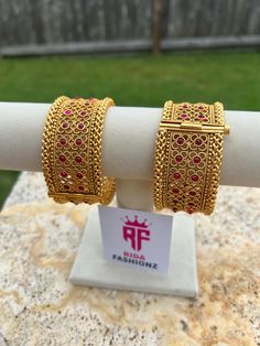 Introducing a luxurious set on Etsy - these Exquisite 925 Silver Bangles are adorned with Ruby stones in a stunning 22k gold matte finish. Each bangle is meticulously crafted to blend traditional elegance with contemporary allure, creating a piece that exudes opulence and sophistication. The combination of pearls, polki, and uncut kundan stones offers a rich and textured appearance, adding a touch of royal charm to any ensemble. Perfect for weddings, festive occasions, or as a statement piece in everyday wear, these bangles promise to elevate your style with their exquisite craftsmanship and timeless design. Embrace the allure of heritage and refinement with these Exquisite 925 Silver Bangles - a symbol of luxury that captures attention and admiration with its intricate detailing and capti Luxury 22k Gold Traditional Jewelry, Ruby Stone, Silver Bangles, 22k Gold, Matte Gold, Favorite Jewelry, Timeless Design, Bangle Bracelets, 925 Silver