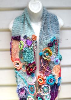 a multicolored knitted scarf with flowers on it