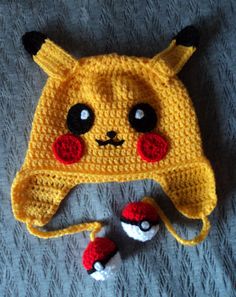 a crocheted pokemon hat and two poke balls