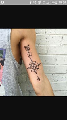 a woman with a tattoo on her arm has an arrow in the shape of a star