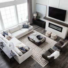 a living room filled with furniture and a flat screen tv mounted on the wall above a fireplace