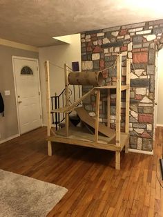 a living room with wood flooring and brick wall in the background is a spiral staircase